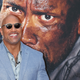 A tiny Dwayne Johnson being stared down by a much bigger Dwayne Johnson.